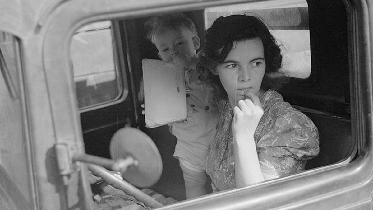 A migrant woman with a small child in an old 1930s era vehicle. Oskaloosa, Kansas. October 1938. Credits: John Vachon; The Library of Congress, Prints & Photographs Division