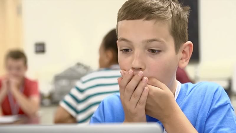 A student looks surprised after learning about his family background from DNA ancestry results.