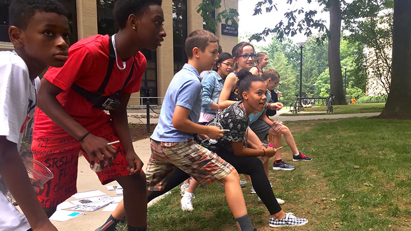 Students lineup ready to run during an exercise about how different bird beak types, adaptations, and mutations influence evolution.